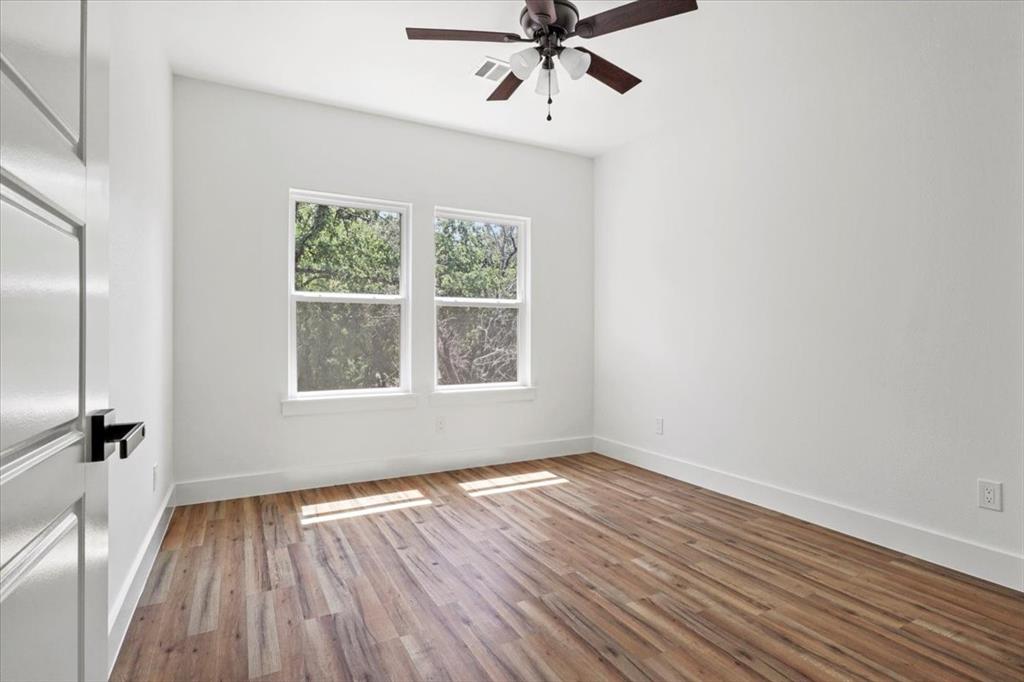 1791 JE Woody Road Springtown, TX 76082 - Photo 28 of 33 wooden floor in an empty room with a window