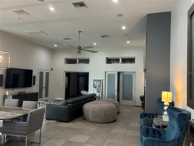 a living room with furniture a flat screen tv and kitchen view