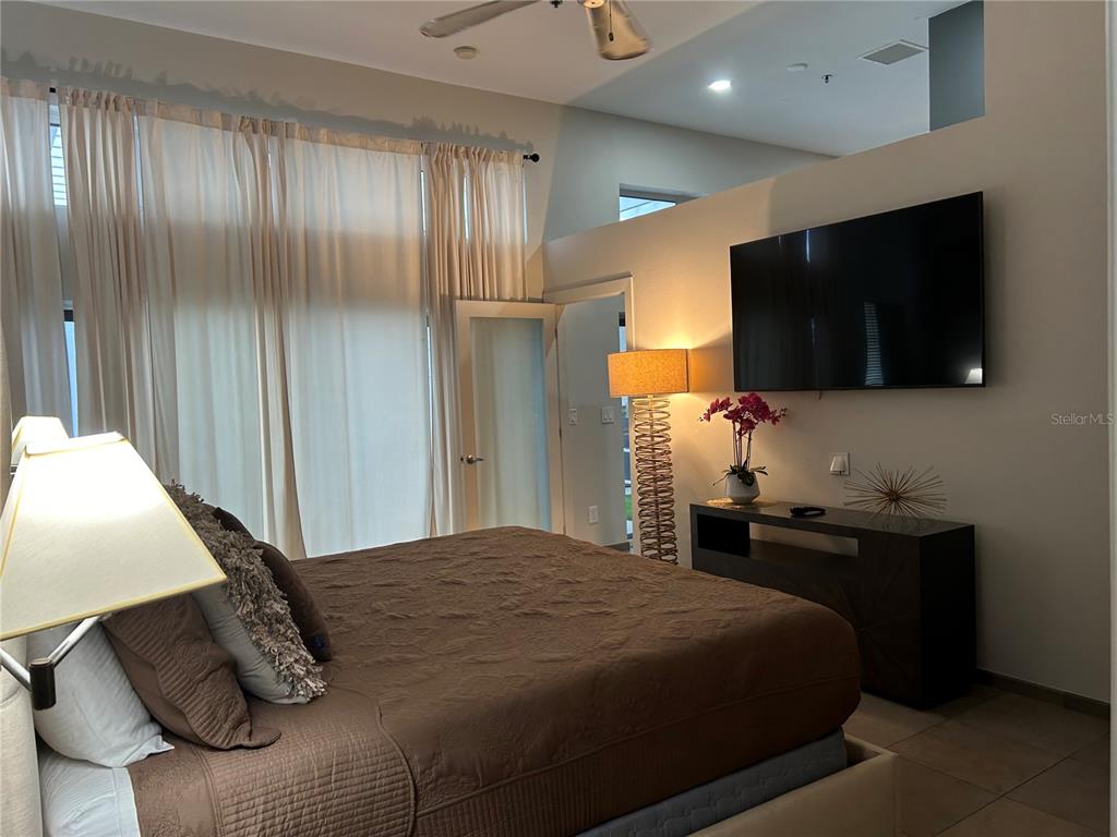 1345 2nd Street, Unit C Sarasota, FL 34236 - Photo 32 of 56 a bedroom with a large bed and a flat tv screen
