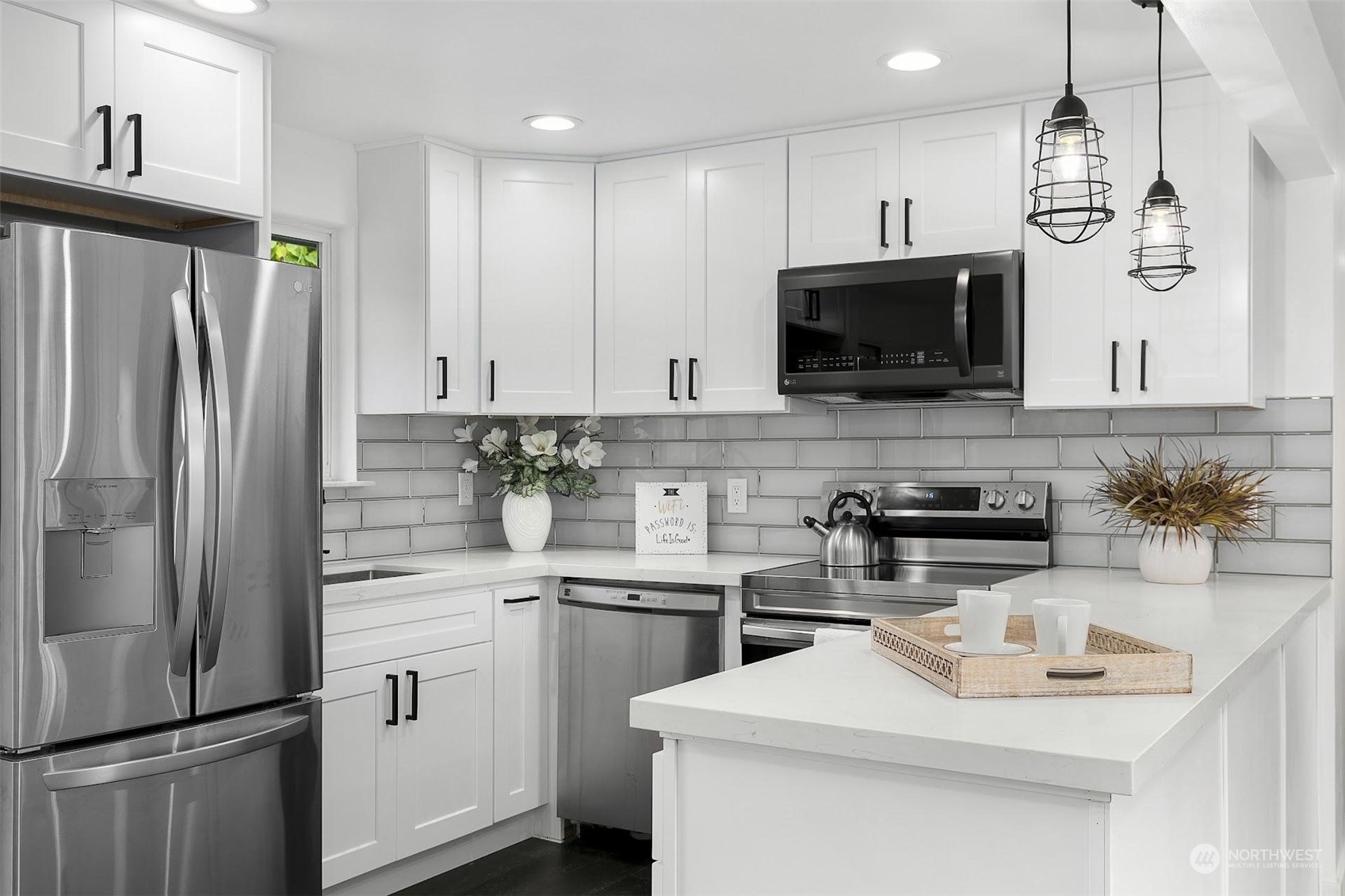 3512 Talbot Road South Renton, WA 98055 - Photo 8 of 21 a kitchen with stainless steel appliances white cabinets a sink a stove a refrigerator and a center island