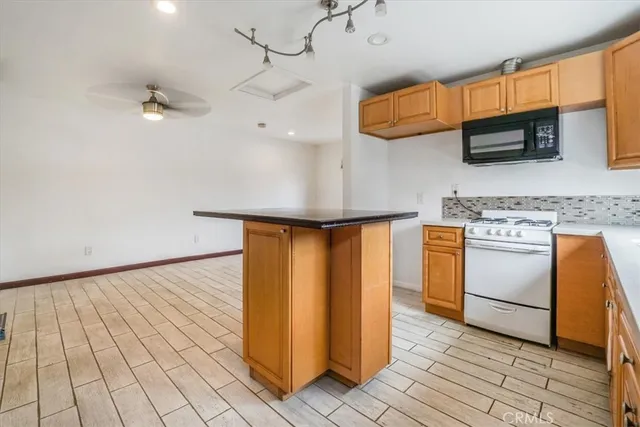 a kitchen with white cabinets and appliances
