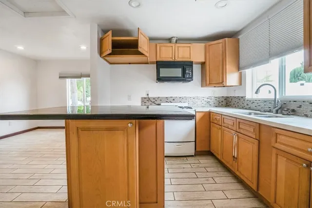 a kitchen with stainless steel appliances granite countertop a sink stove and cabinets