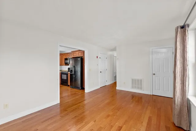 a view of a big room with wooden floor and windows