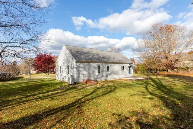 a view of a big house with a big yard and large trees