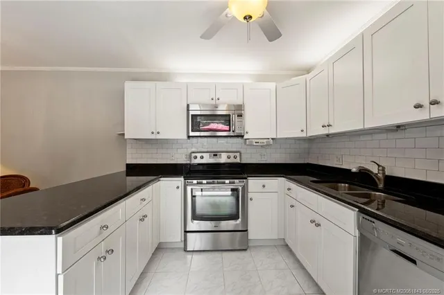 a kitchen with granite countertop a sink and a stove top oven