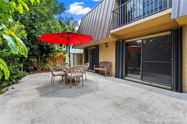 an outdoor sitting area with red umbrella