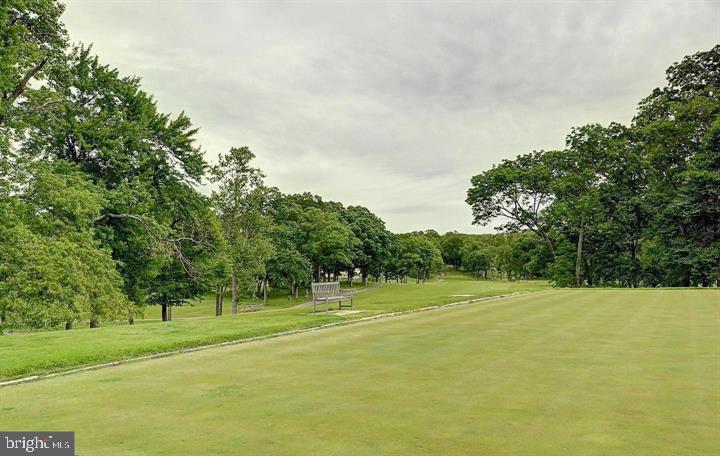 3200 North Leisure World Boulevard, Unit 203 Silver Spring, MD 20906 - Photo 31 of 32 a view of a tennis ground with trees in the background