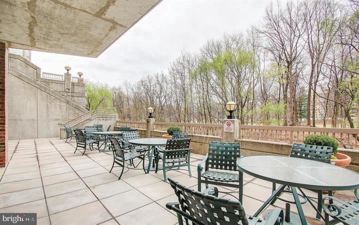 3200 North Leisure World Boulevard, Unit 203 Silver Spring, MD 20906 - Photo 4 of 32 a view of a patio with table and chairs and potted plants