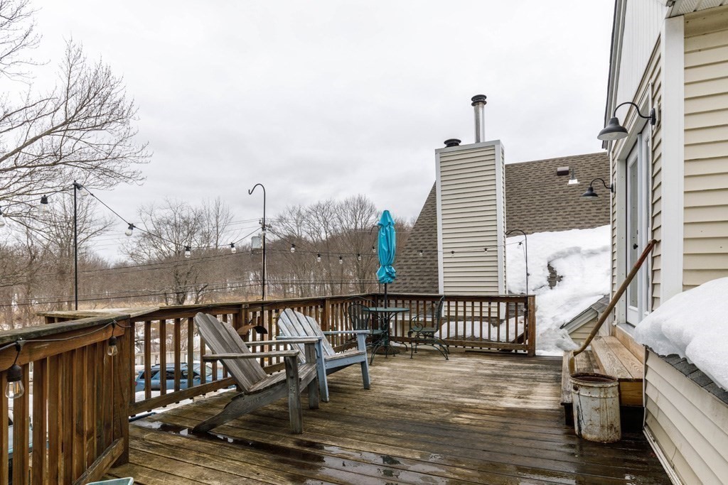 14 Travers Street Gardner, MA 01440 - Photo 12 of 17 a balcony with wooden floor next to a yard