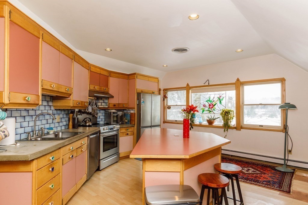 14 Travers Street Gardner, MA 01440 - Photo 2 of 17 a kitchen with stainless steel appliances a stove a sink a microwave a dining table and chairs