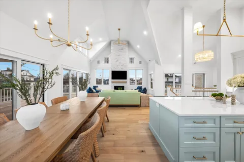 a dining room with stainless steel appliances kitchen island granite countertop a table chairs and a living room view