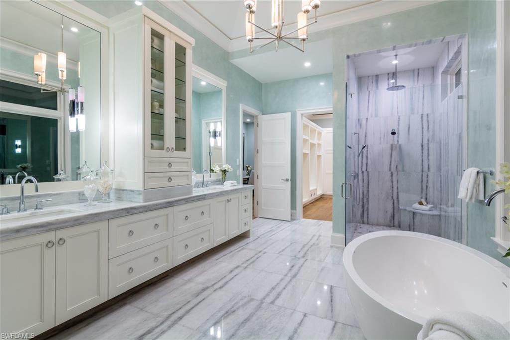 870 Nelson`s Walk Naples, FL 34102 - Photo 12 of 24 a spacious bathroom with a double vanity sink a large mirror and a bathtub