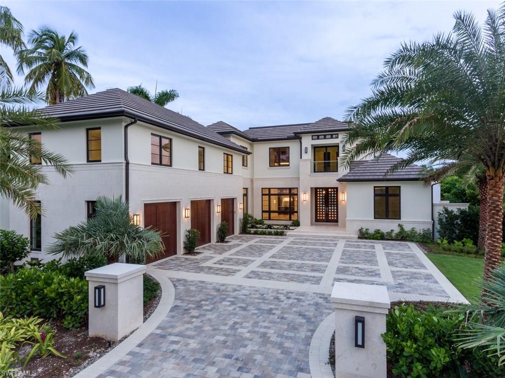870 Nelson`s Walk Naples, FL 34102 - Photo 2 of 24 a front view of a house with a yard and garage