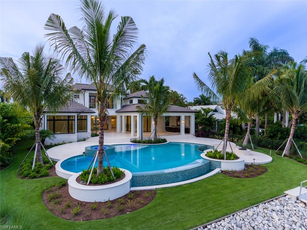 870 Nelson`s Walk Naples, FL 34102 - Photo 22 of 24 a front view of a house with a garden and swimming pool