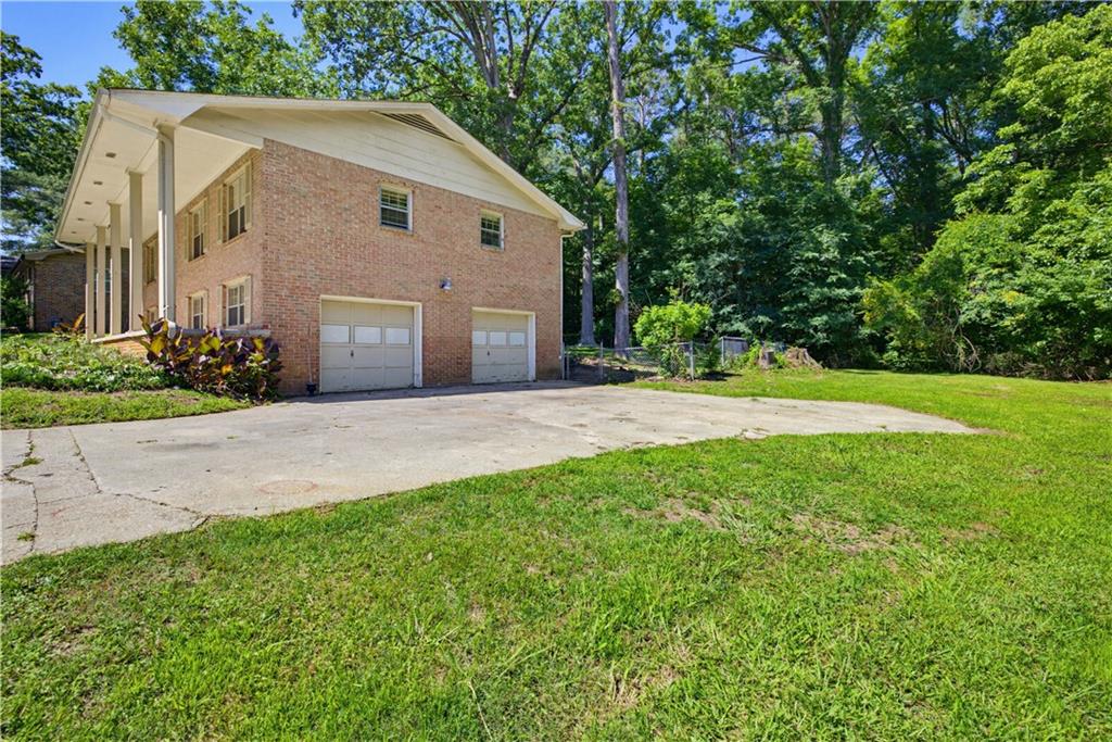 4188 Cedar Valley Lane Conley, GA 30288 - Photo 2 of 28 a front view of a house with a yard and garage