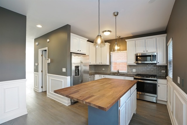 4152 South Berkeley Avenue Chicago, IL 60653 - Photo 5 of 15 a kitchen with stainless steel appliances granite countertop a sink stove and refrigerator