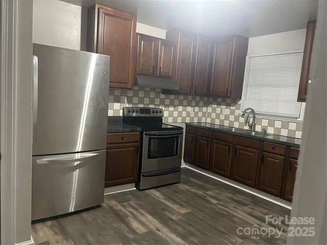 a kitchen with stainless steel appliances granite countertop a refrigerator stove a sink and dishwasher