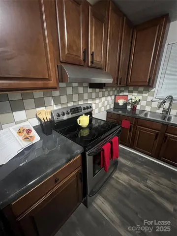 a kitchen with stainless steel appliances granite countertop a stove a sink and a microwave