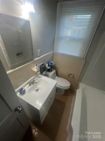 a bathroom with a sink mirror and toilet