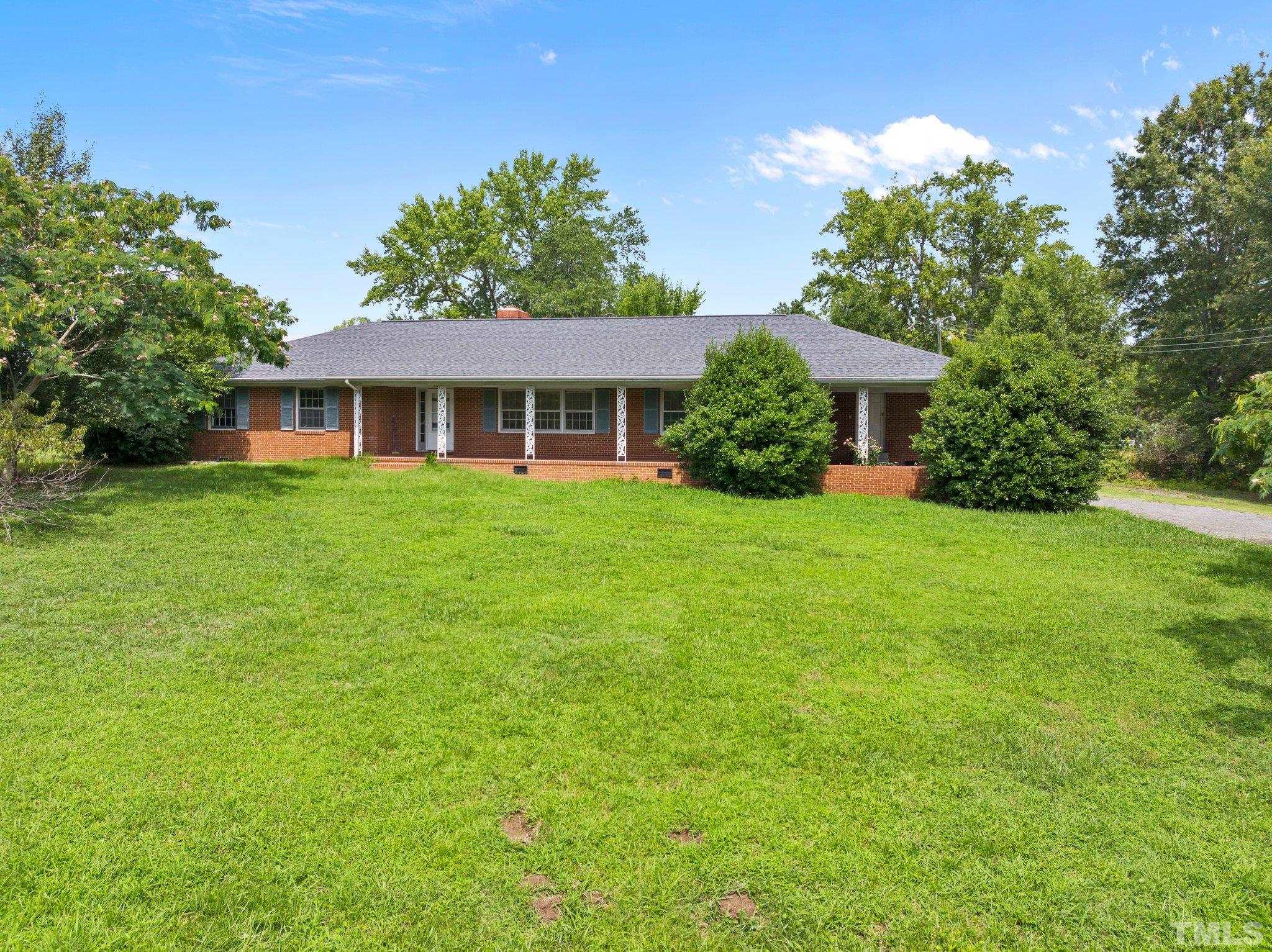 104 West Tally Ho Road Stem, NC 27581 - Photo 1 of 25 a front view of a house with a yard and trees