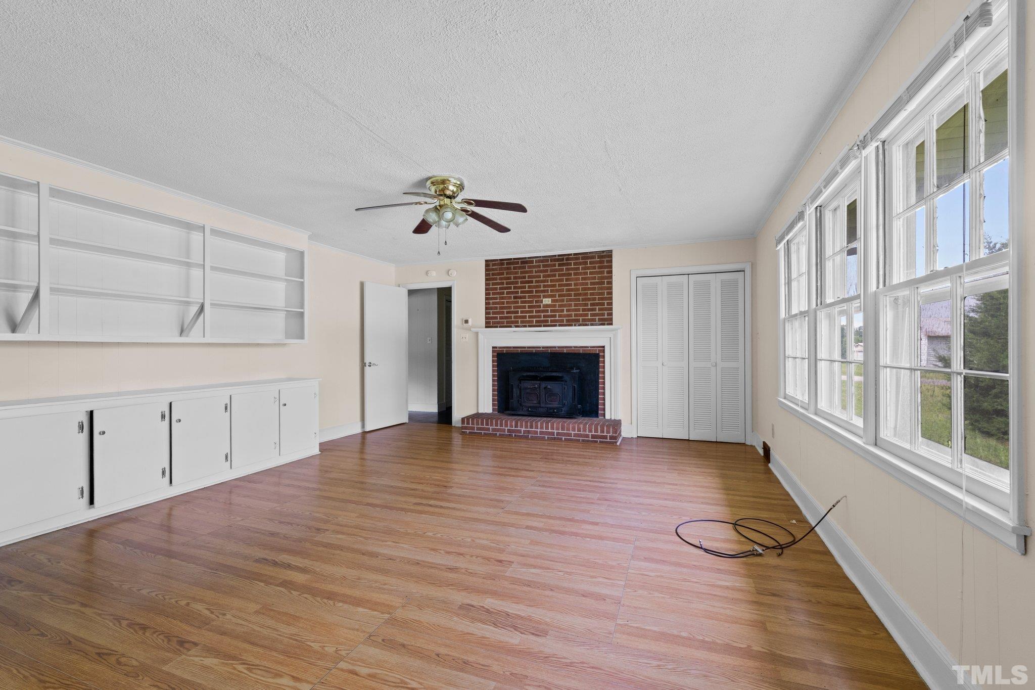 104 West Tally Ho Road Stem, NC 27581 - Photo 17 of 25 wooden floor in an empty room with a fireplace and a window