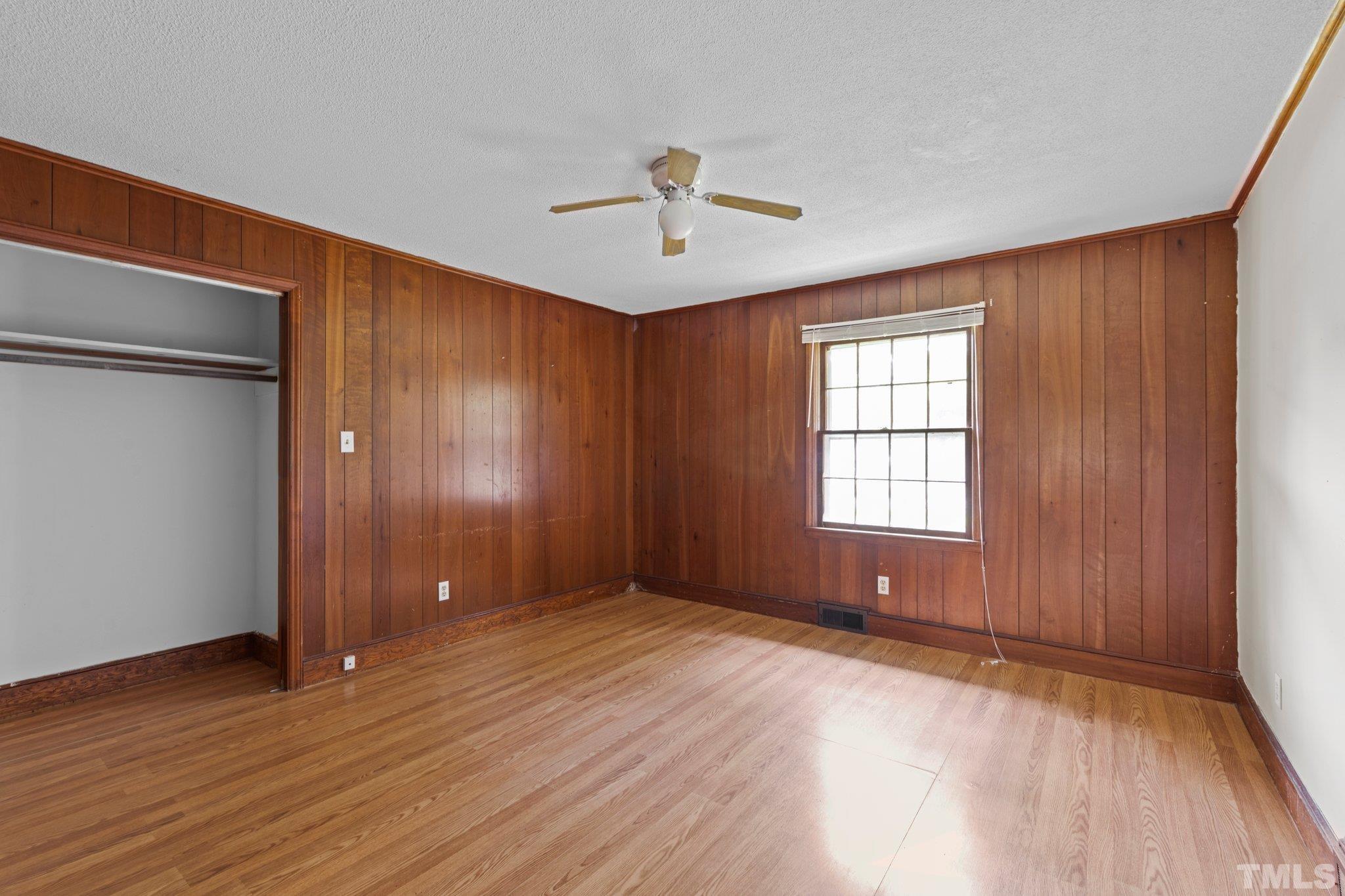 104 West Tally Ho Road Stem, NC 27581 - Photo 22 of 25 an empty room with wooden floor chandelier fan and windows