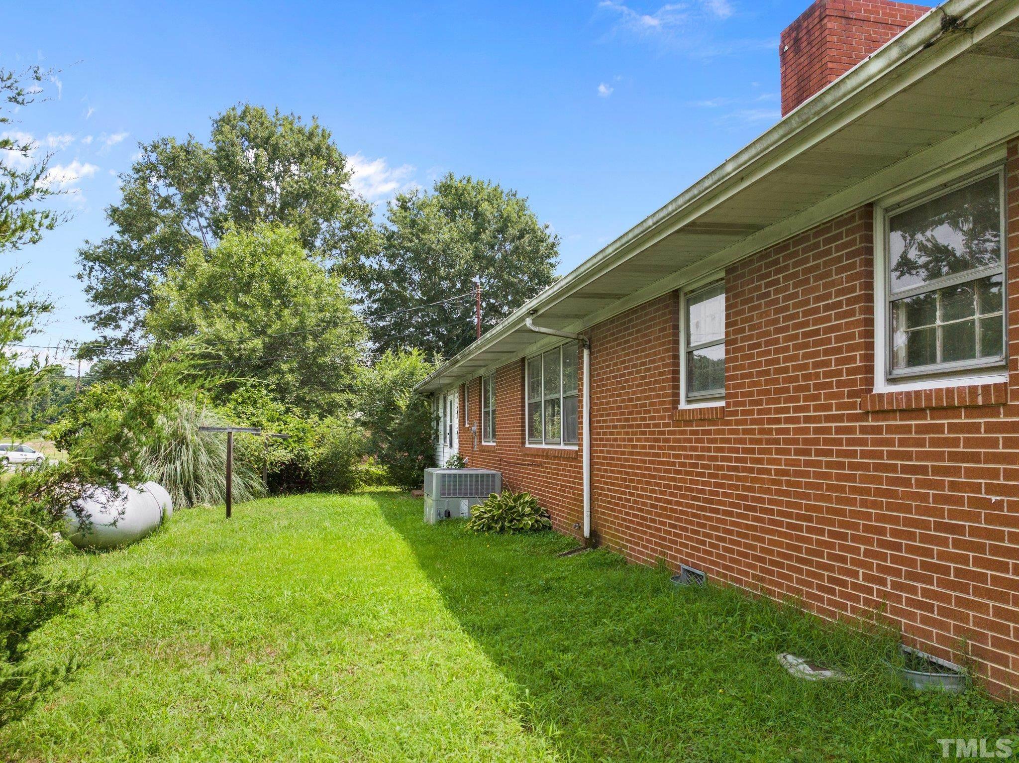104 West Tally Ho Road Stem, NC 27581 - Photo 8 of 25 a view of a backyard with plants and large tree