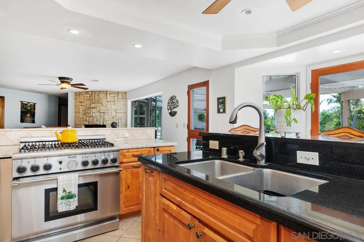 15121 Country Hill Road Poway, CA 92064 - Photo 11 of 40 a kitchen with kitchen island granite countertop a sink stainless steel appliances and cabinets