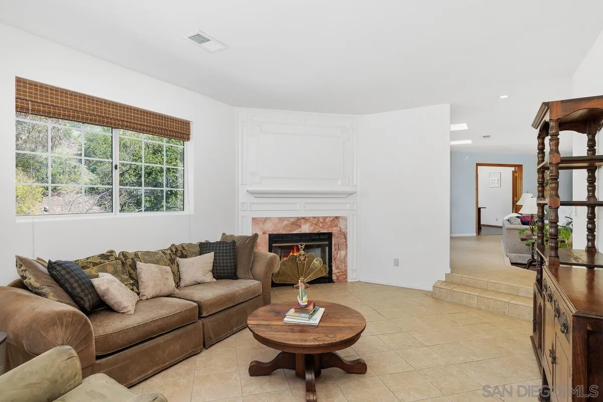 15121 Country Hill Road Poway, CA 92064 - Photo 15 of 40 a living room with furniture a fireplace and a large window