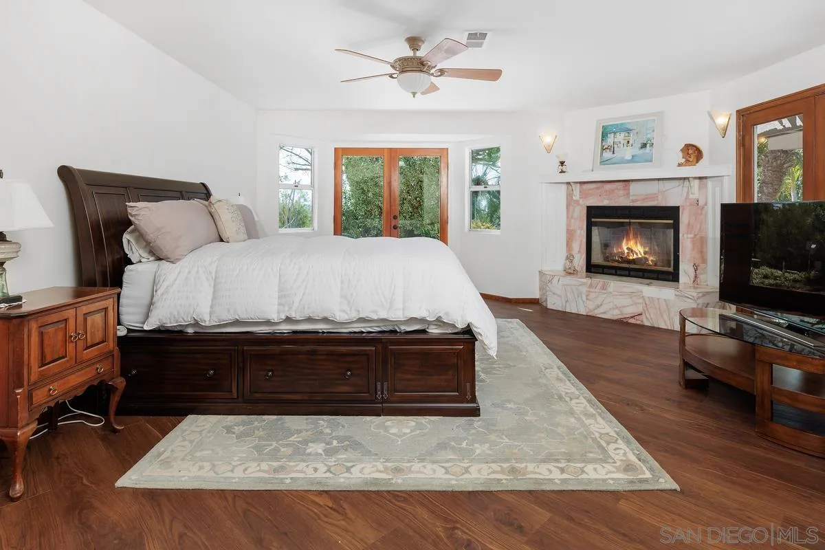 15121 Country Hill Road Poway, CA 92064 - Photo 19 of 40 a spacious bedroom with a bed and a fireplace