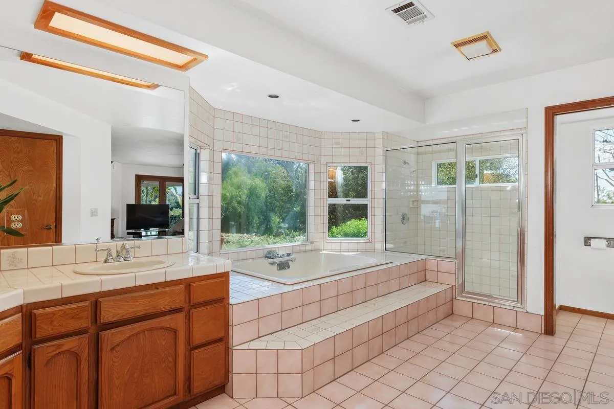15121 Country Hill Road Poway, CA 92064 - Photo 21 of 40 a bathroom with a tub sink and mirror