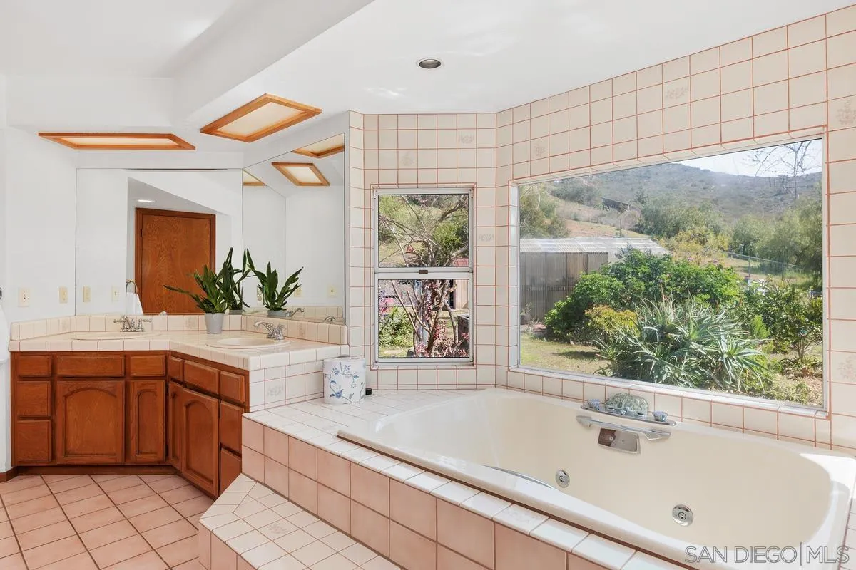 15121 Country Hill Road Poway, CA 92064 - Photo 22 of 40 a bathroom with a bathtub sink and mirror
