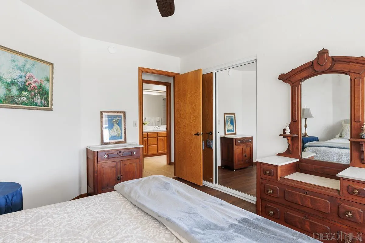 15121 Country Hill Road Poway, CA 92064 - Photo 24 of 40 a bedroom with a bed and a chandelier