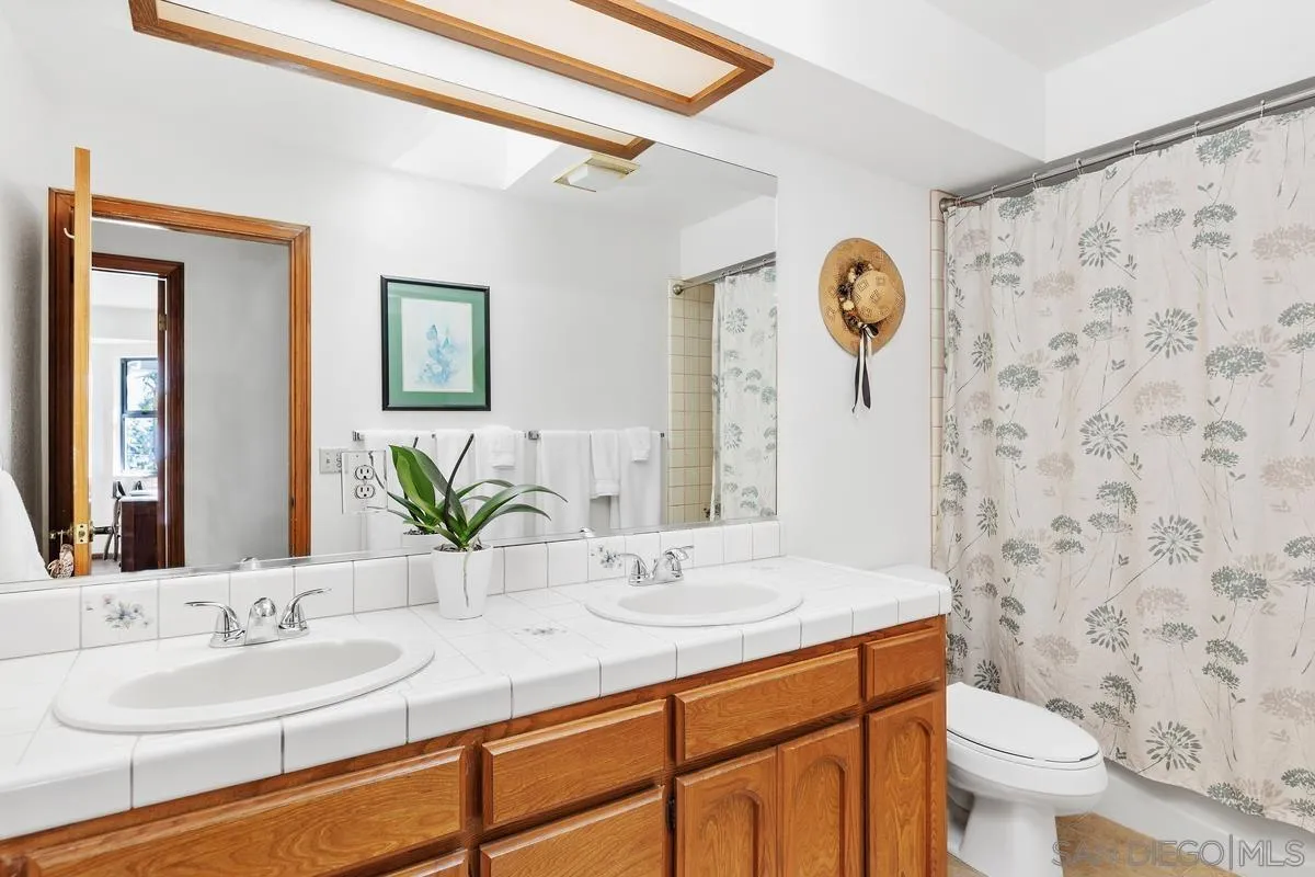 15121 Country Hill Road Poway, CA 92064 - Photo 25 of 40 a bathroom with a granite countertop sink mirror and toilet