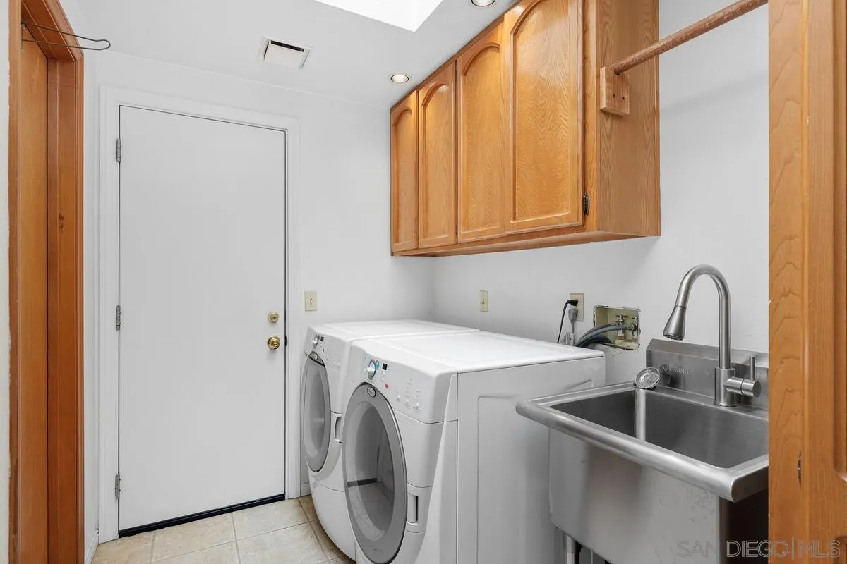 15121 Country Hill Road Poway, CA 92064 - Photo 33 of 40 a kitchen with a sink a washer and dryer