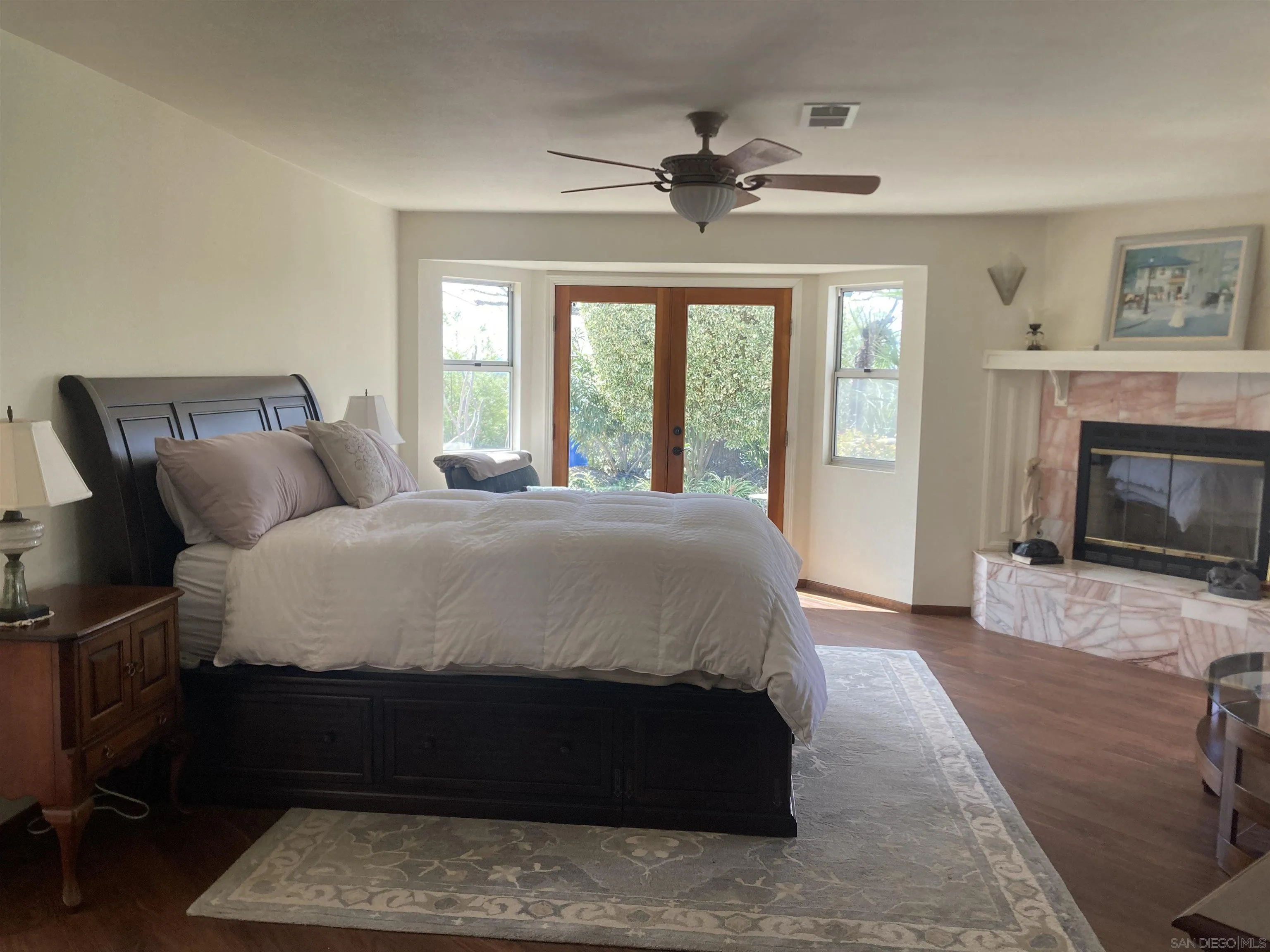 15121 Country Hill Road Poway, CA 92064 - Photo 39 of 40 a spacious bedroom with a bed a fireplace and a large window