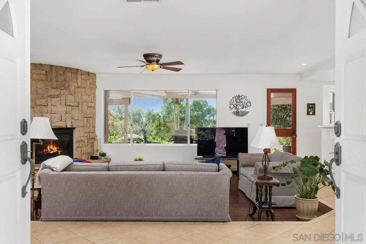 15121 Country Hill Road Poway, CA 92064 - Photo 4 of 40 a living room with furniture a fireplace and a large window