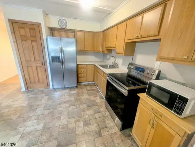 a kitchen with stainless steel appliances granite countertop a refrigerator a stove top oven a sink and dishwasher
