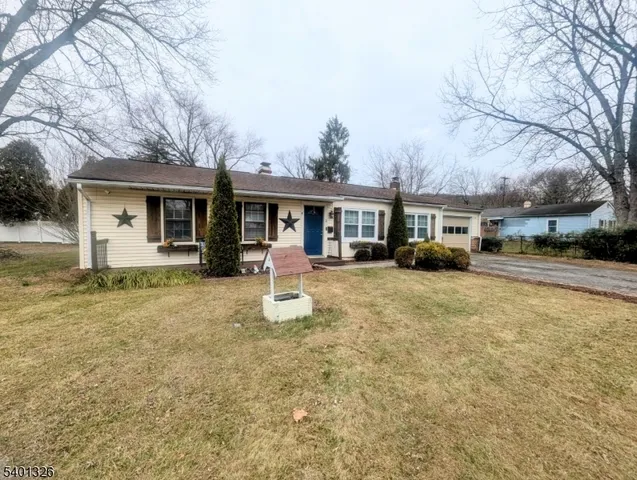 a front view of a house with a yard and trees