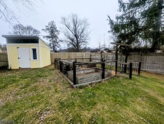 a view of a backyard with wooden fence and a bench