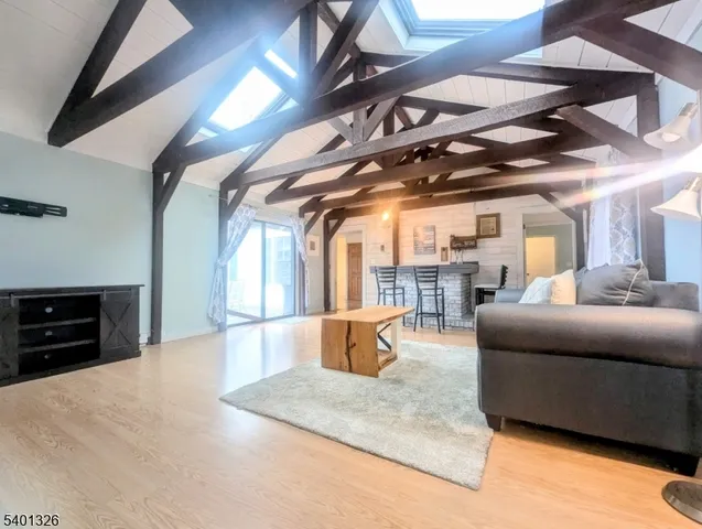 a living room with stainless steel appliances furniture and a kitchen view