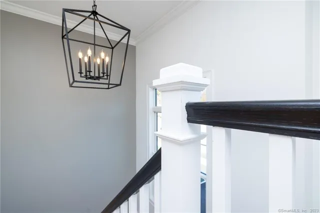 a view of a hallway with wooden floor and chandelier