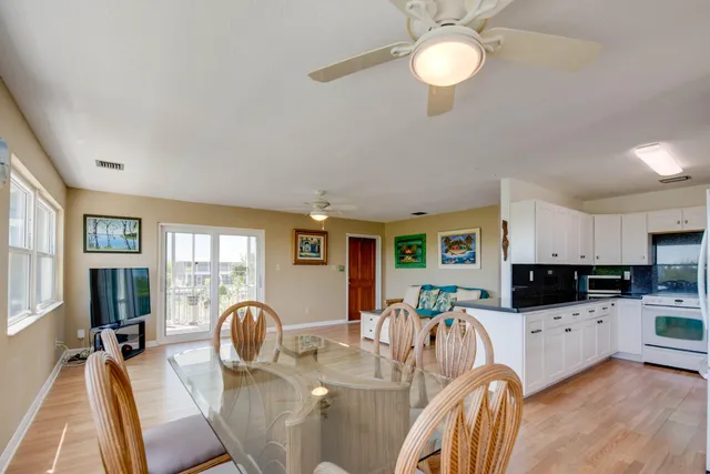 a living room with furniture a flat screen tv and kitchen view