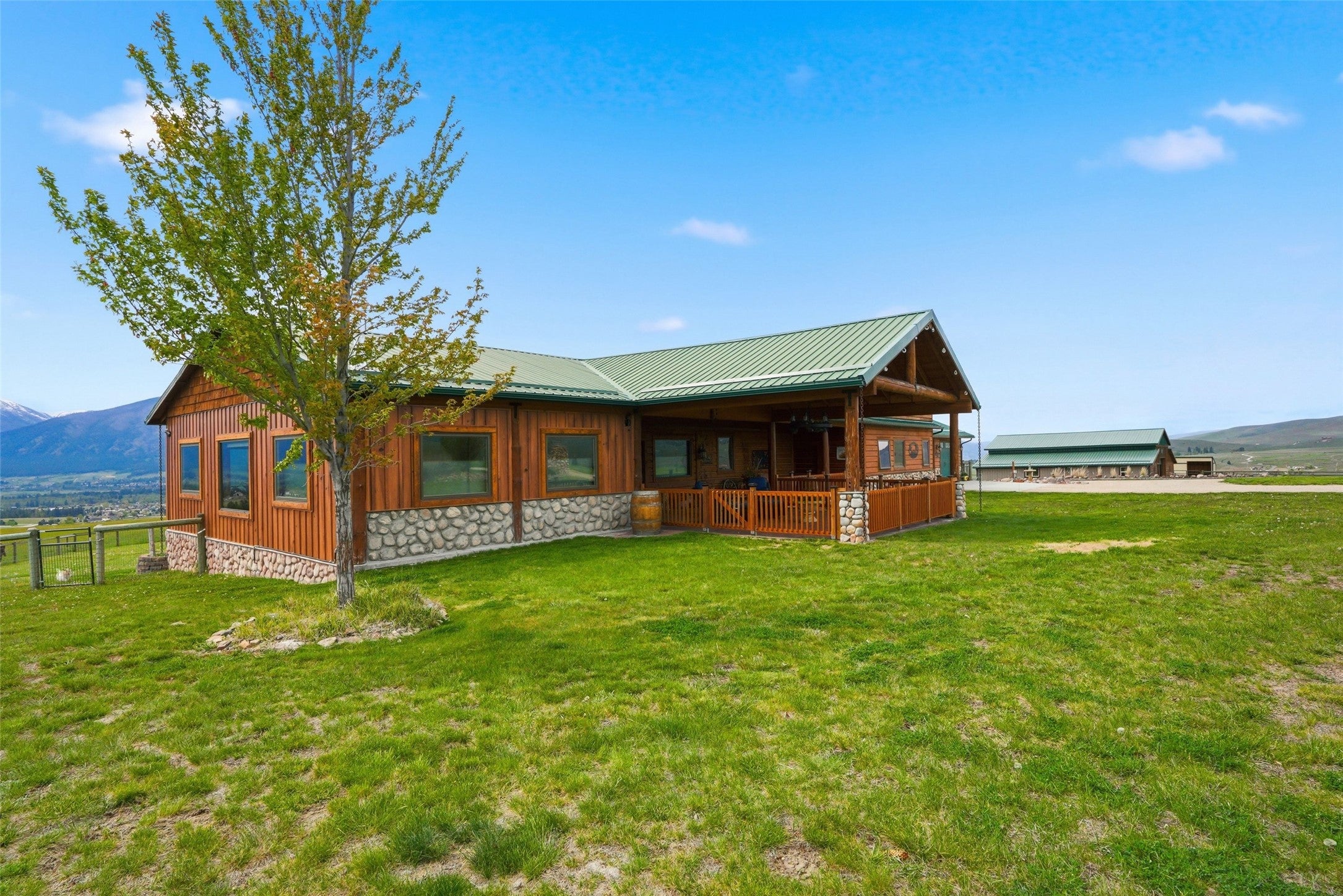 679 Hidden Valley Road North Florence, MT 59833 - Photo 11 of 85 Cabin-style exterior featuring a green metal roof, wood siding, and a stone base