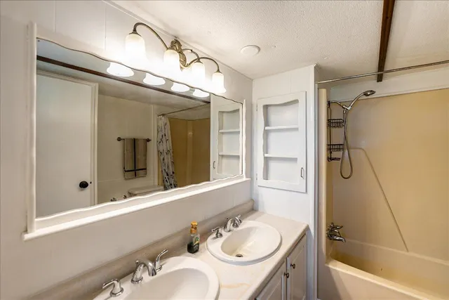 a bathroom with a granite countertop sink toilet and shower