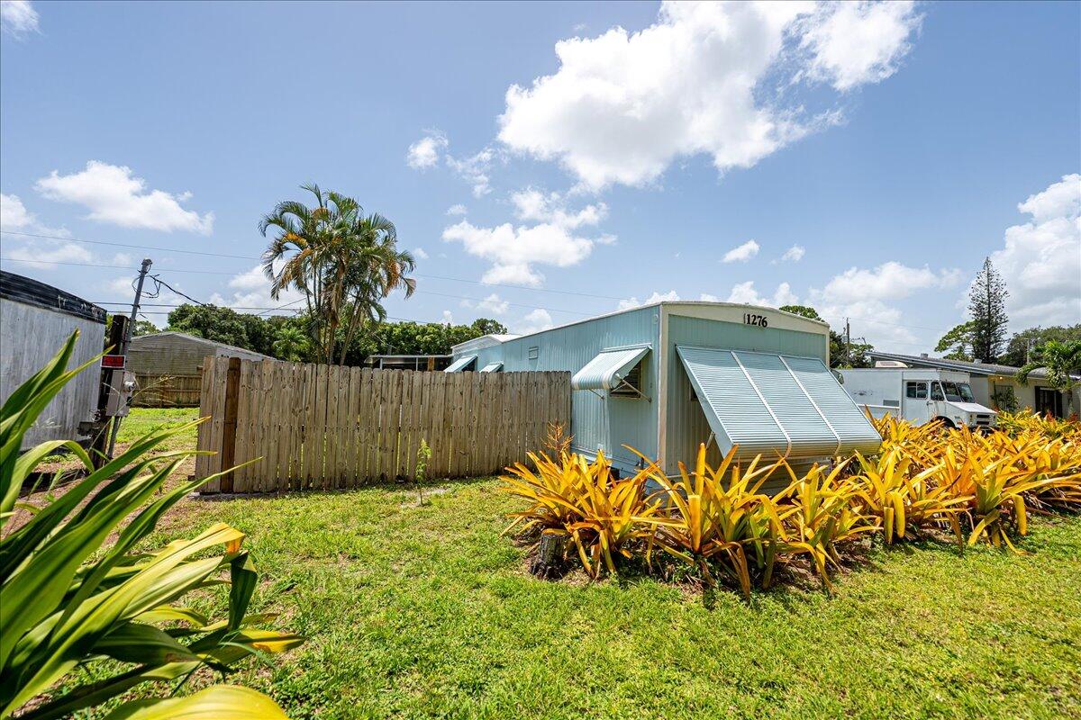 1276 Southwest Tropical Terrace Stuart, FL 34997 - Photo 22 of 27 a view of a garden with a bench