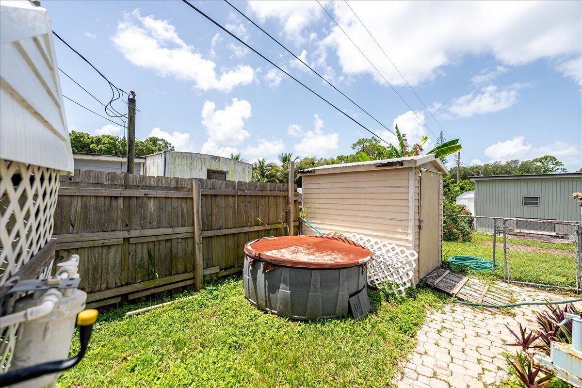 1276 Southwest Tropical Terrace Stuart, FL 34997 - Photo 26 of 27 a backyard of a house with table and chairs