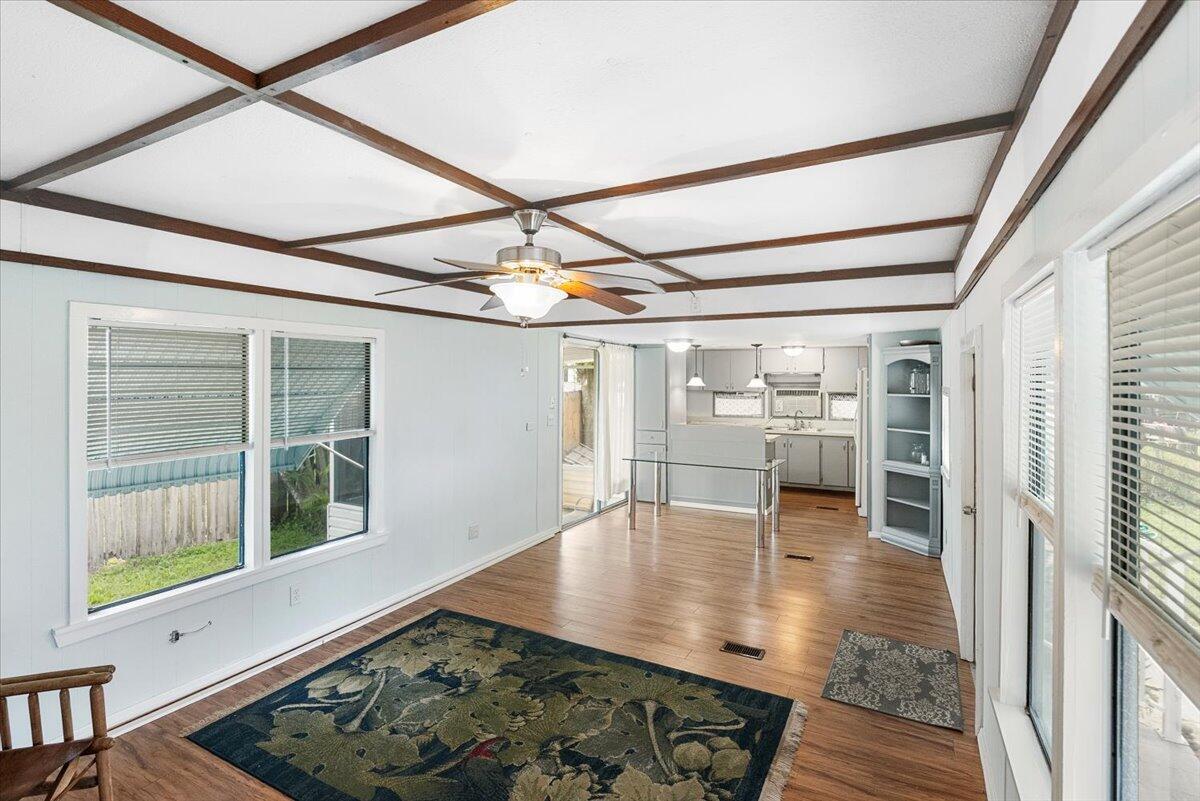 1276 Southwest Tropical Terrace Stuart, FL 34997 - Photo 8 of 27 a view of an empty room with wooden floor and a window