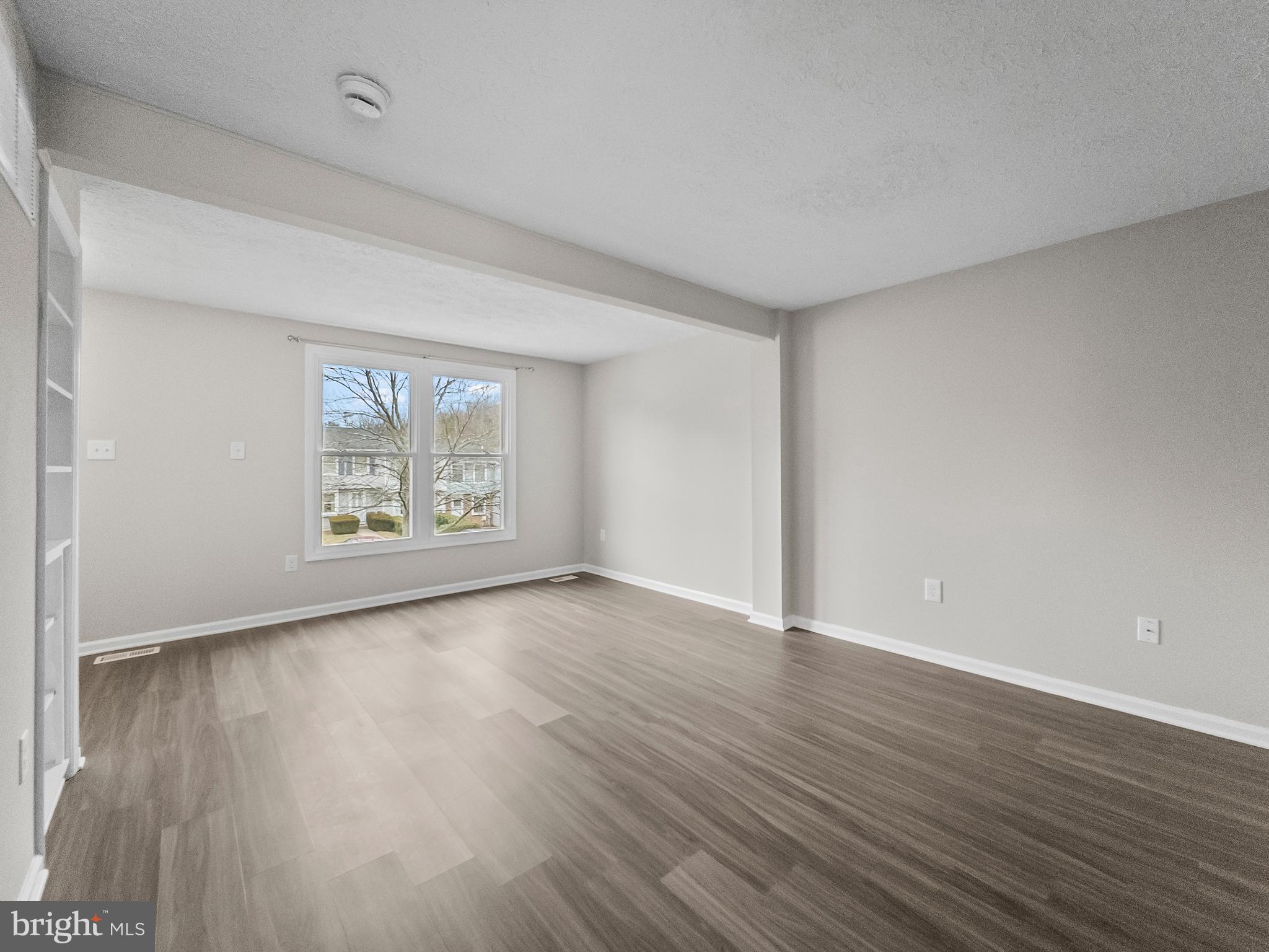 10110 Shelldrake Circle Damascus, MD 20872 - Photo 5 of 35 a view of an empty room with wooden floor and a window