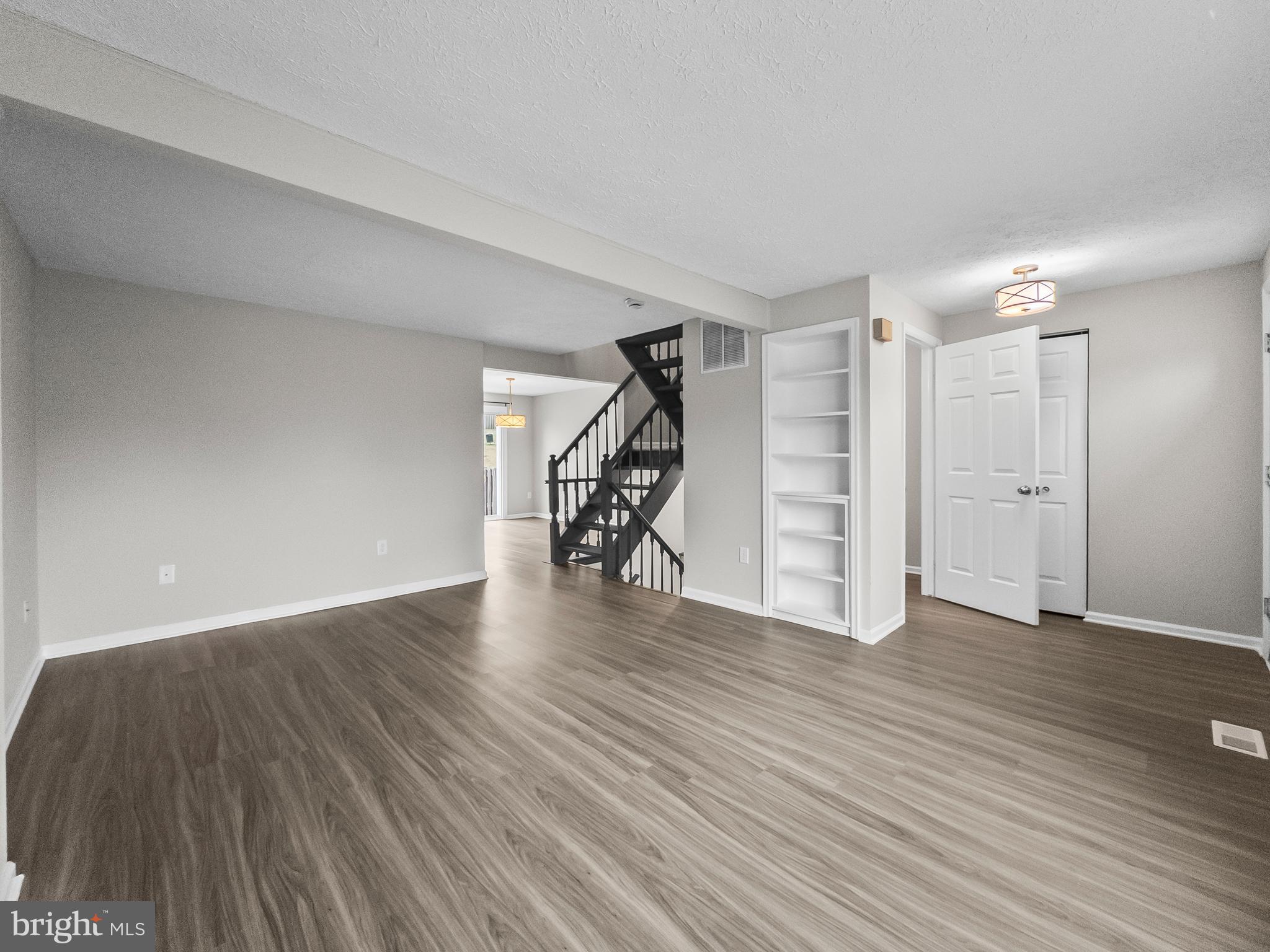 10110 Shelldrake Circle Damascus, MD 20872 - Photo 6 of 35 a view of an empty room with wooden floor stairs and windows
